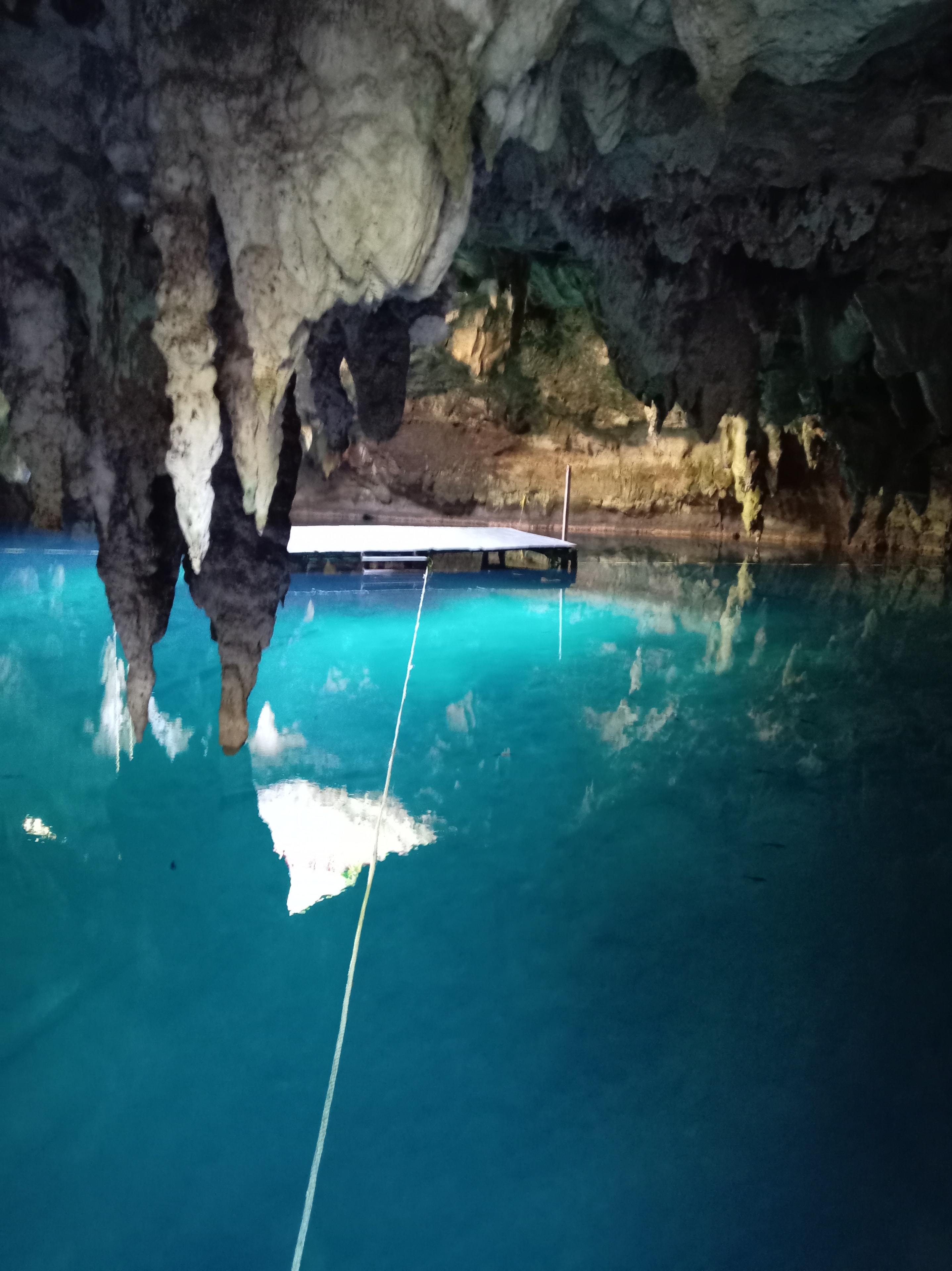 Cueva de cenote con estalactitas, agua turquesa y lancha — La Noria