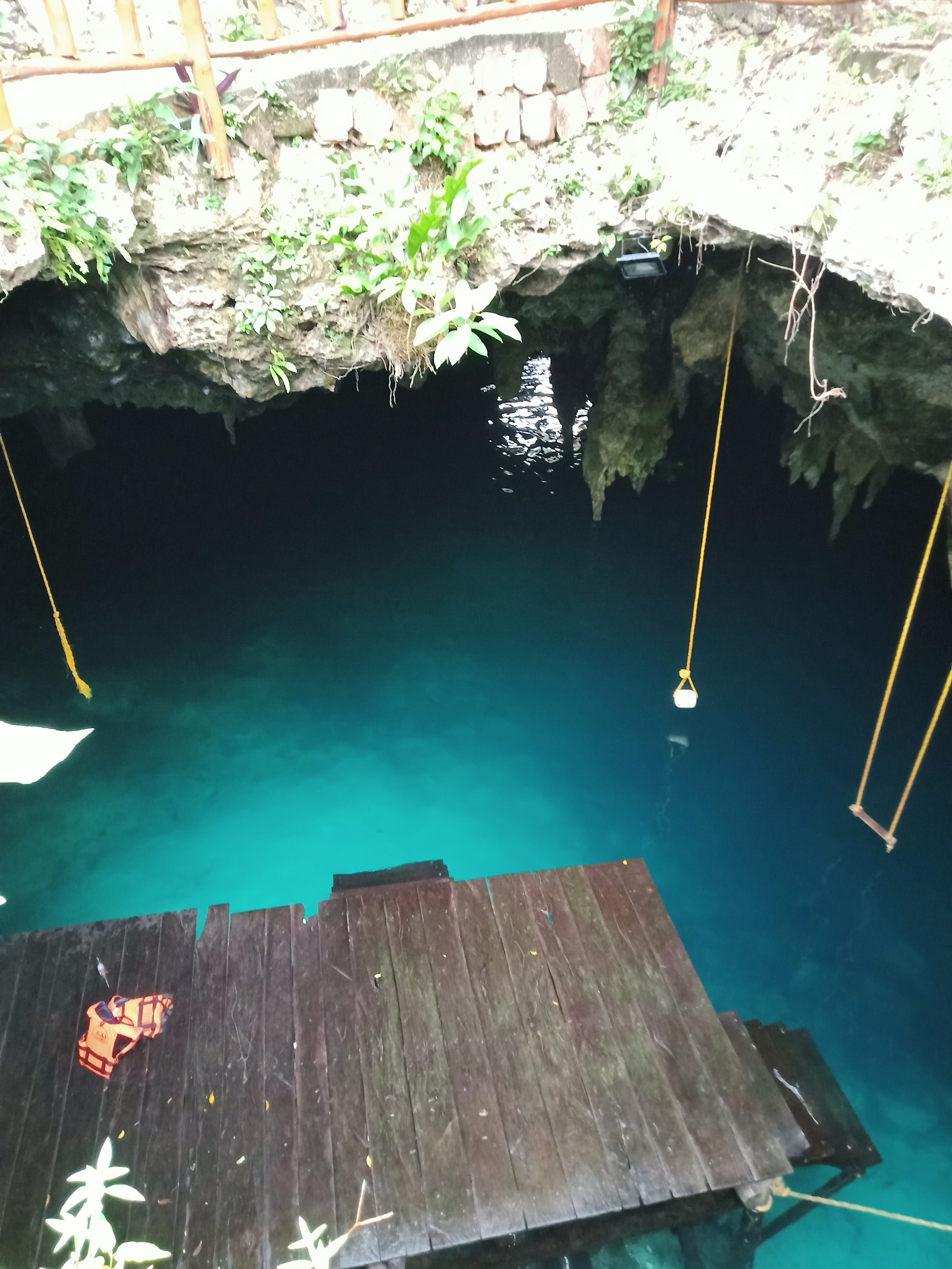 Cenote La Noria con plataforma de madera, cuerdas y agua turquesa